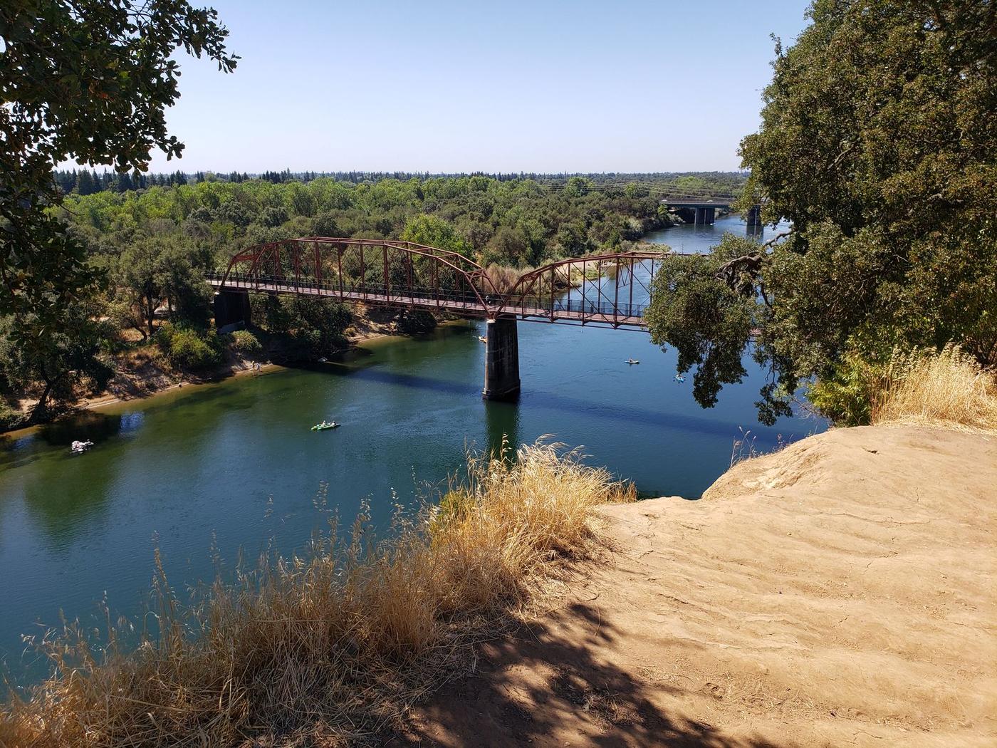 The Fair Oaks Bridge over the American River, seen from the bluffs through bare oak branches