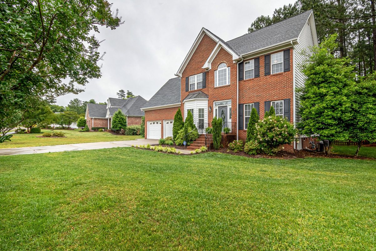 A two-story brick home with a wide green front lawn