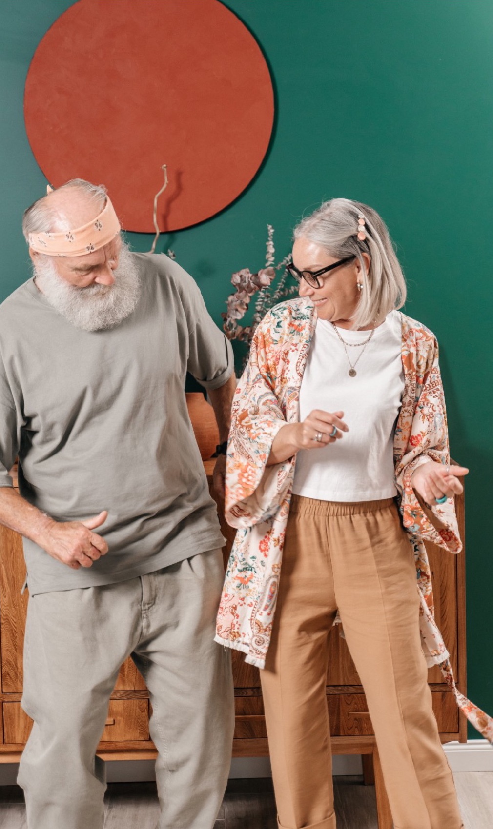 A happy older couple dancing in a bright living room, smiling at each other